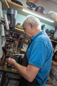 A team member from Al's Attire making a pair of shoes